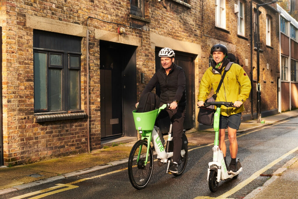 Two people riding Lime e-scooters